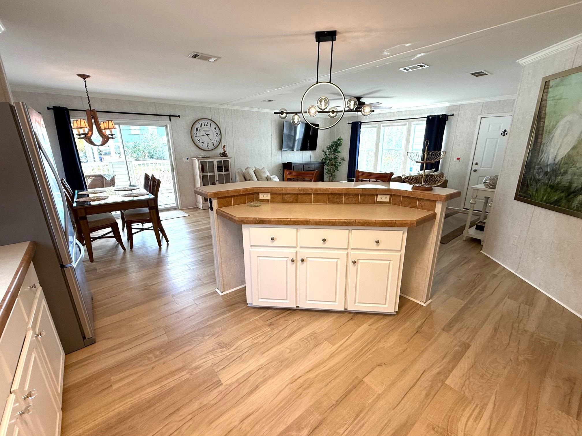 292 Majorca Road St. Augustine, FL 32080 - Photo 32 of 32 Kitchen featuring hanging lights, freestanding refrigerator, open floor plan, white cabinetry, and light wood-style flooring