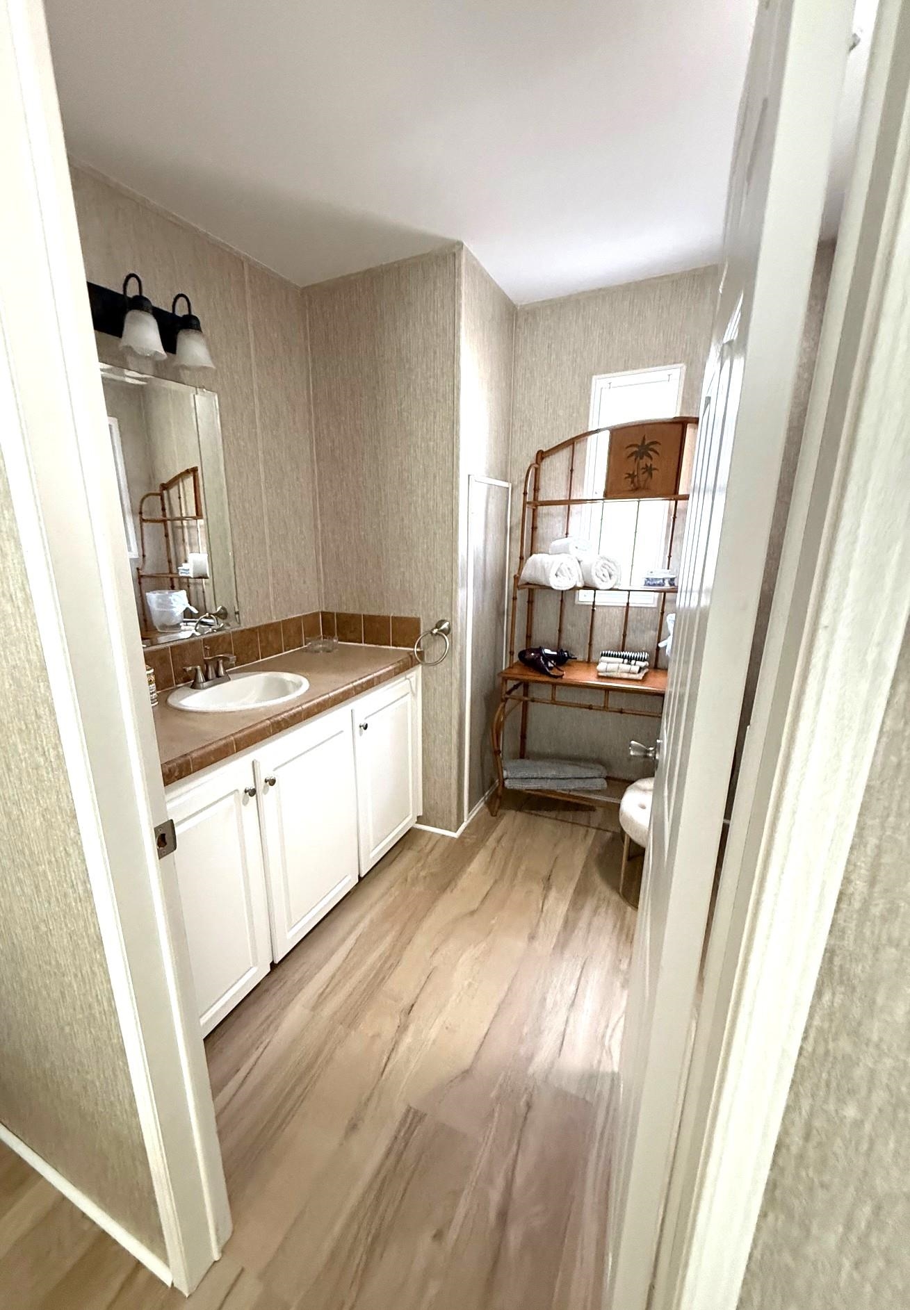 292 Majorca Road St. Augustine, FL 32080 - Photo 19 of 32 Bathroom with vanity, light wood-style flooring, and wallpapered walls
