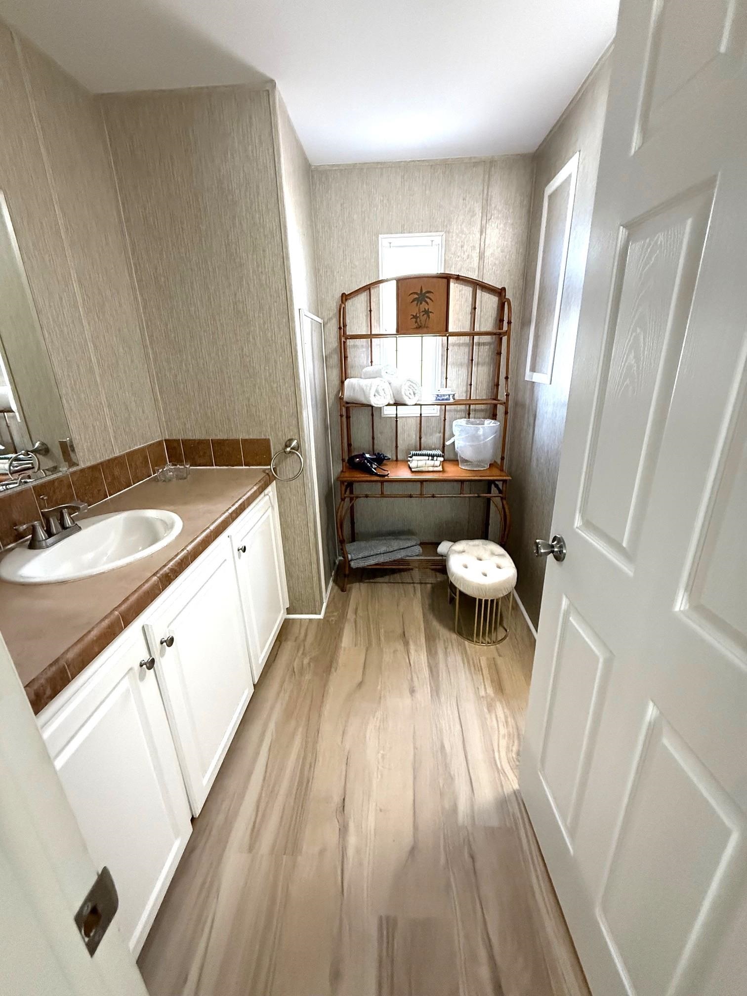 292 Majorca Road St. Augustine, FL 32080 - Photo 28 of 32 Bathroom featuring double vanity, wallpapered walls, and light wood finished floors