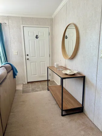 a bedroom with a bed a mirror on dresser and a window