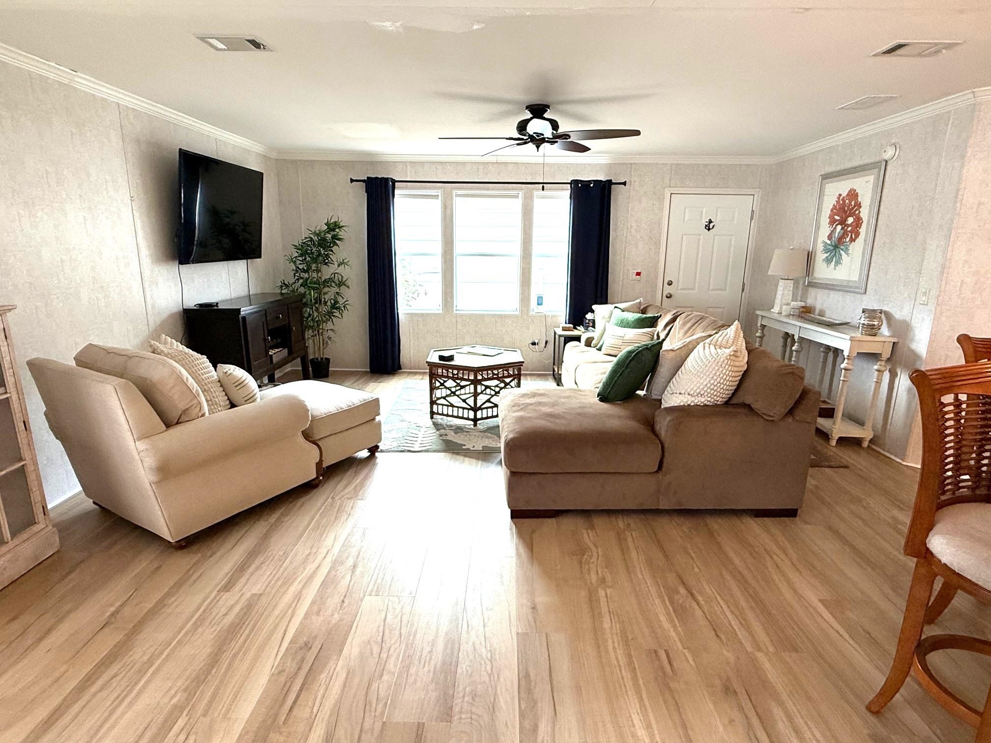 292 Majorca Road St. Augustine, FL 32080 - Photo 7 of 32 Living room with light wood-style floors, crown molding, wallpapered walls, and ceiling fan