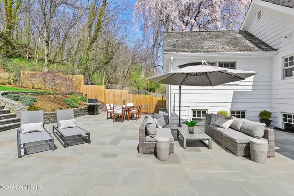 a view of a patio with a table and chairs under an umbrella
