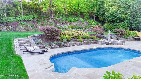 a swimming pool with outdoor seating and yard