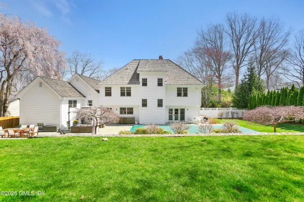 a front view of house with garden and trees