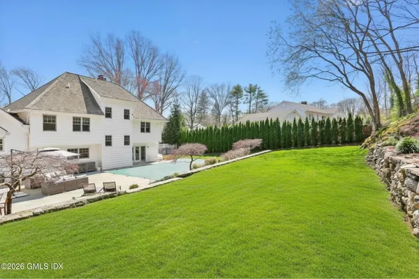 a front view of a house with garden and trees
