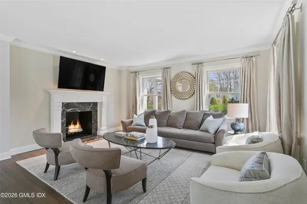 a living room with furniture a fireplace and a window