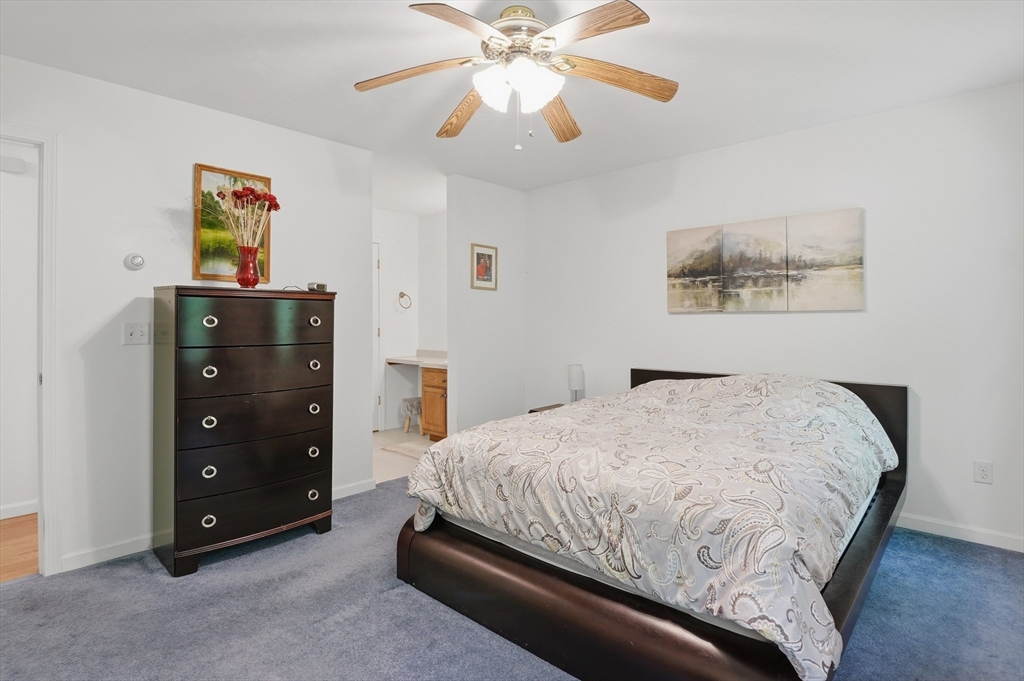186 Common Street Groton, MA 01450 - Photo 16 of 28 a bedroom with a bed and a chandelier