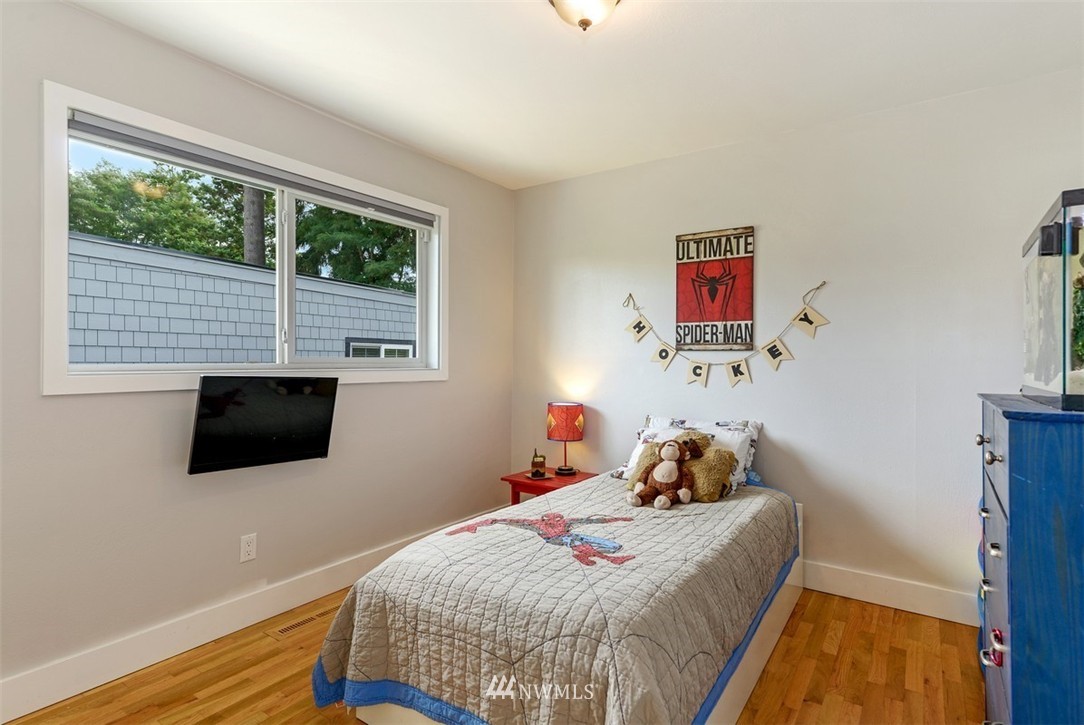 808 Electron Way Fircrest, WA 98466 - Photo 11 of 20 a bedroom with a bed and wooden floor