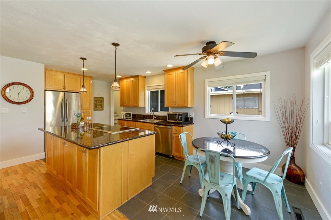 808 Electron Way Fircrest, WA 98466 - Photo 5 of 20 a kitchen with a dining table chairs sink and stove