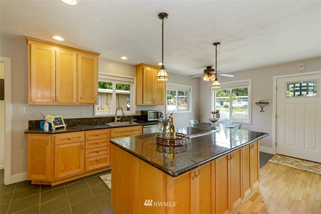808 Electron Way Fircrest, WA 98466 - Photo 7 of 20 a kitchen with kitchen island granite countertop a sink a counter top space and living room view