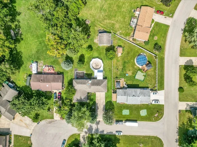 an aerial view of a large pool with lawn chairs and plants