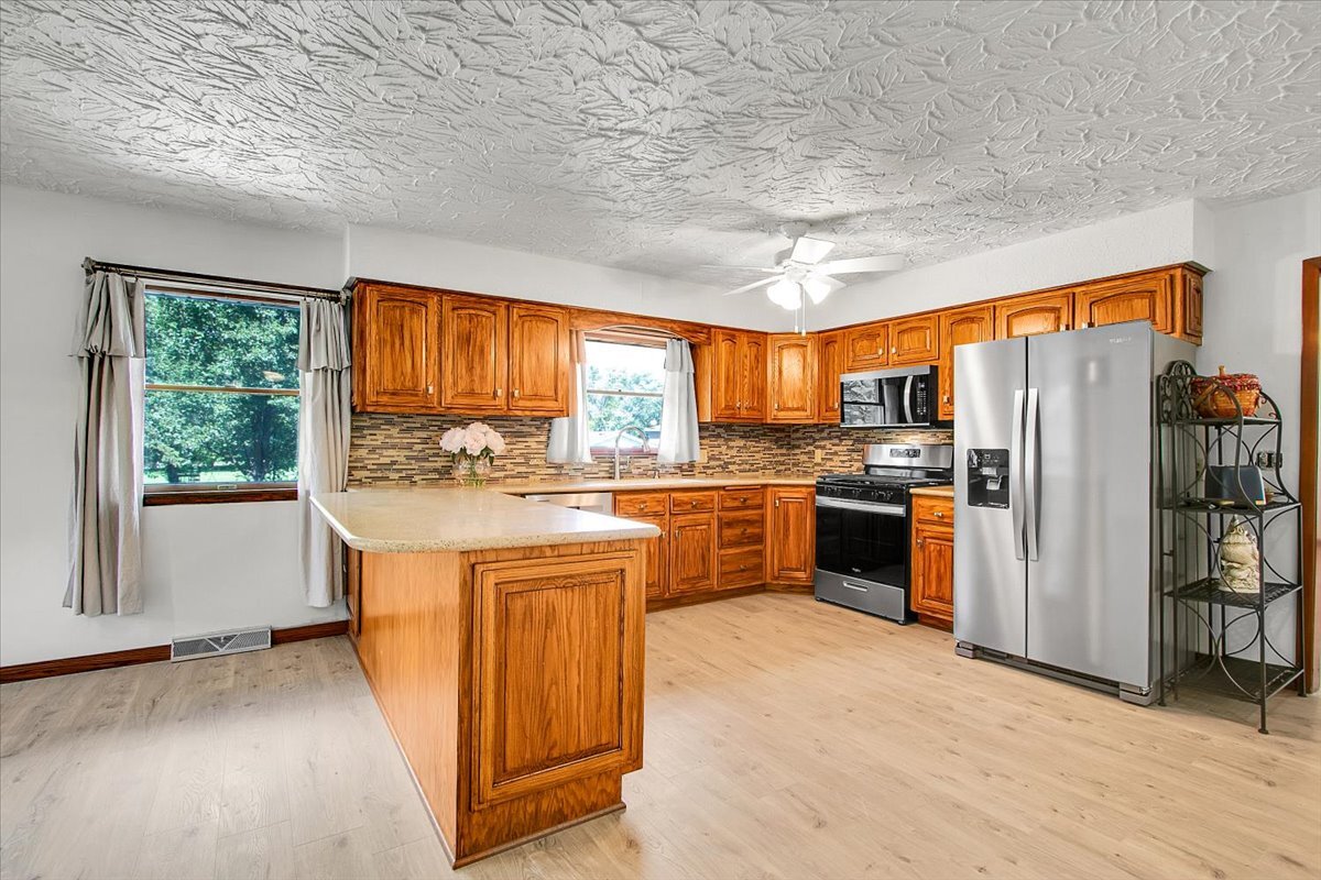 25734 Hickory Court Minooka, IL 60447 - Photo 6 of 35 a kitchen with stainless steel appliances granite countertop a refrigerator a sink a stove and island
