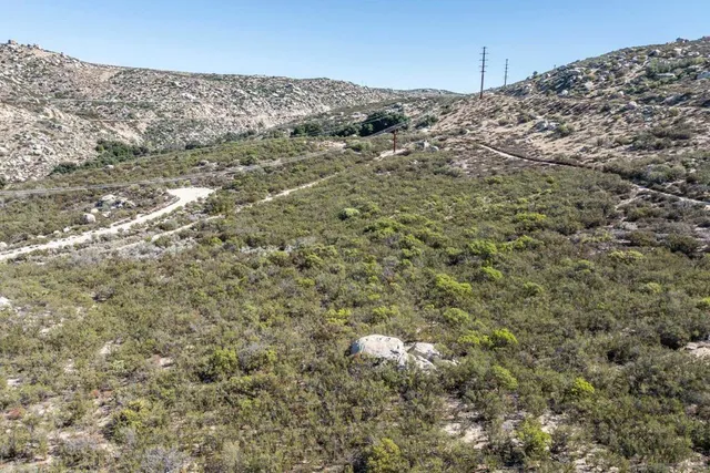 an aerial view of residential houses with outdoor space and trees