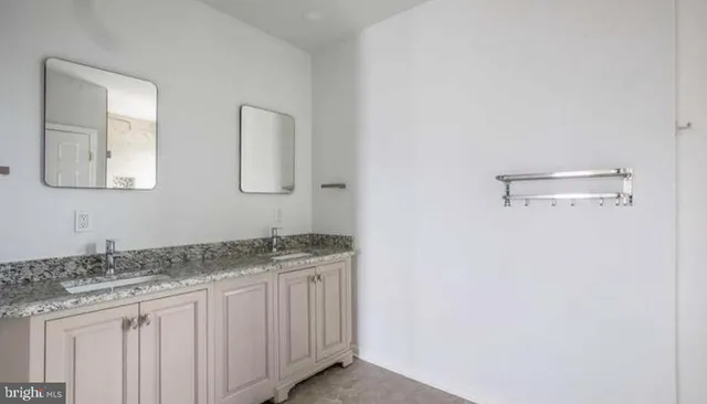 a bathroom with a granite countertop sink and mirror