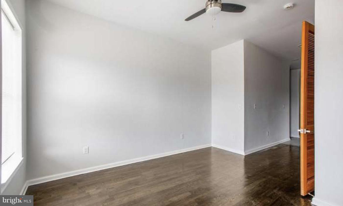 815 North Calhoun Street Baltimore, MD 21217 - Photo 20 of 38 an empty room with wooden floor cabinets and windows