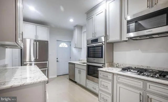 a kitchen with stainless steel appliances granite countertop a stove and a refrigerator
