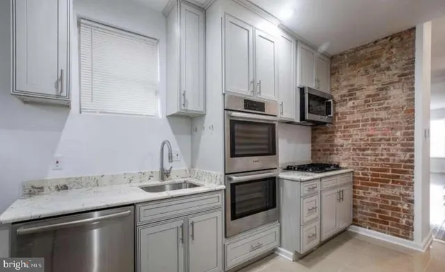 a kitchen with stainless steel appliances a sink stove and cabinets