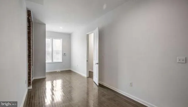 a view of hallway with window and wooden floor