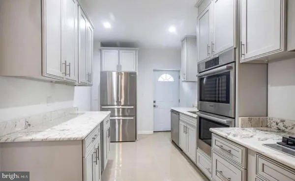 a kitchen with granite countertop stainless steel appliances and wooden cabinets