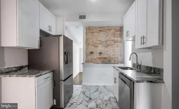 a kitchen with stainless steel appliances granite countertop a refrigerator and a stove top oven
