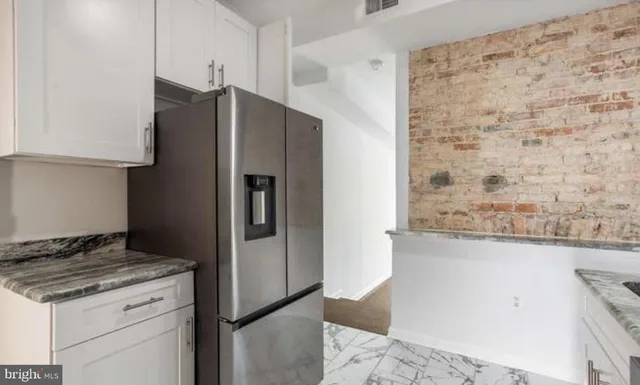 a kitchen with stainless steel appliances granite countertop a refrigerator and a stove