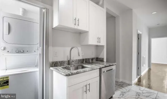 a kitchen with stainless steel appliances granite countertop a sink and a refrigerator