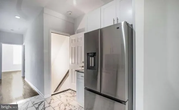 a metallic refrigerator freezer sitting inside of a kitchen