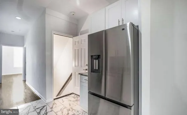 a metallic refrigerator freezer sitting inside of a kitchen