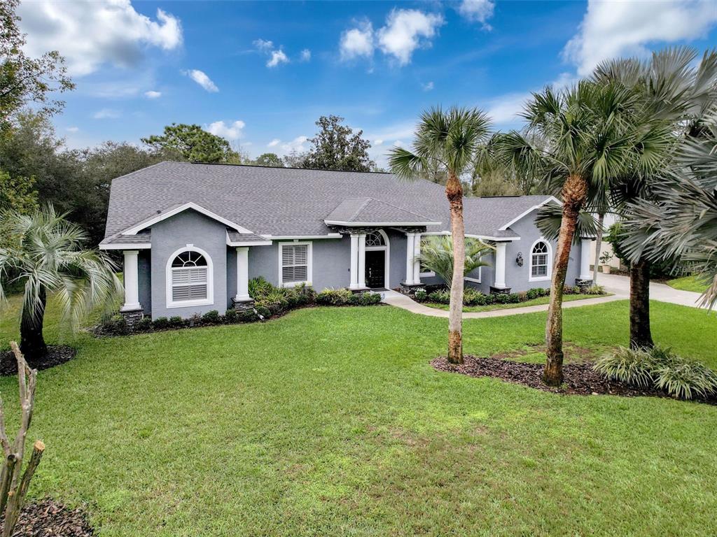 13217 Jessica Drive Spring Hill, FL 34609 - Photo 1 of 1 a house with green field in front of it