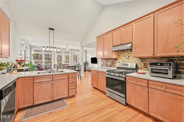 a kitchen with stainless steel appliances granite countertop a stove a sink dishwasher and a refrigerator