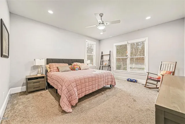 a spacious bedroom with a bed and wooden floor