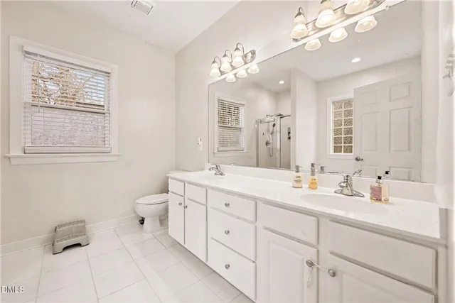 a bathroom with a sink a large mirror and a toilet