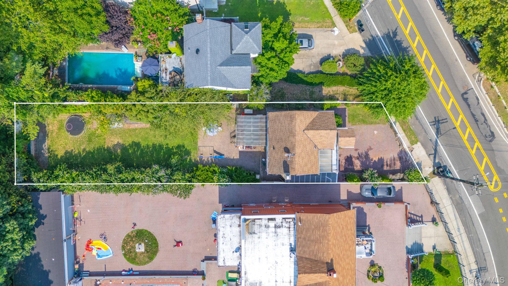 Aerial view of property and surrounding area with a pool area and property parcel outlined