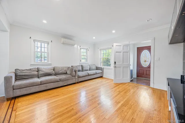 a dining room with wooden floor a chandelier a glass table and chairs
