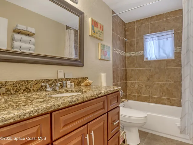 a bathroom with a granite countertop sink a toilet and bathtub
