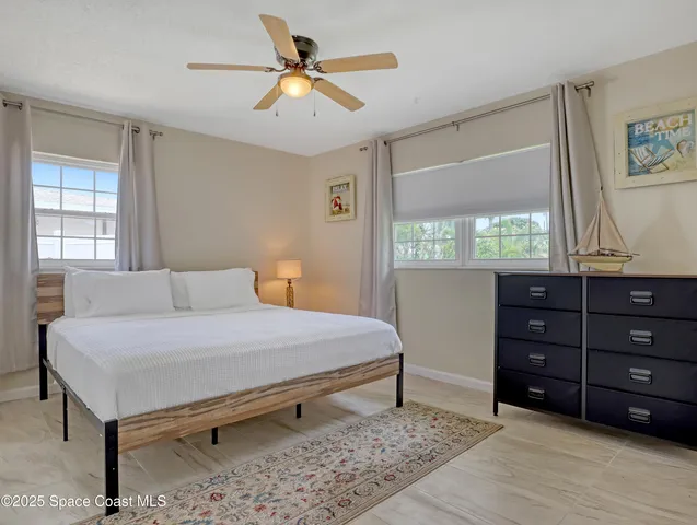 a bedroom with a bed and a dresser next to a window