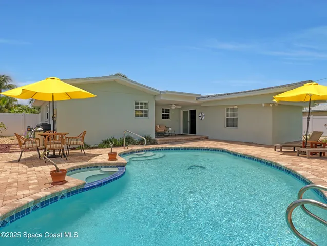 a view of a house with backyard sitting area and swimming pool