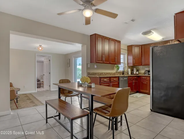 a kitchen with stainless steel appliances kitchen island granite countertop a refrigerator a stove a sink with a dining table and chairs