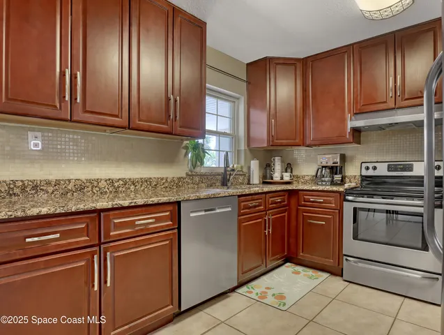 a kitchen with granite countertop cabinets stainless steel appliances and a counter space
