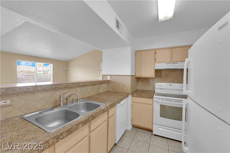 8101 West Flamingo Road, Unit 2030 Las Vegas, NV 89147 - Photo 25 of 27 A well-lit kitchen featuring a breakfast bar and essential appliances for daily living.