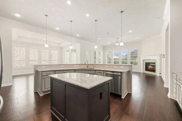 a kitchen with a sink chandelier and wooden floor