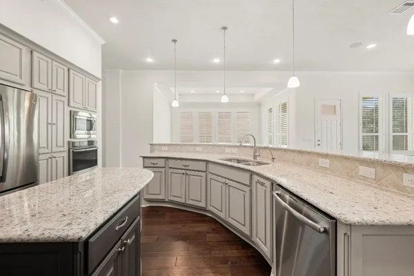 an open kitchen with granite countertop kitchen island a sink appliances and a counter space