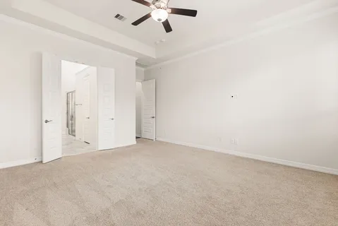 an empty room with a ceiling fan and window