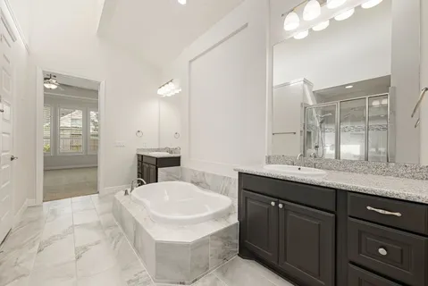 a bathroom with a sink double vanity granite and a mirror