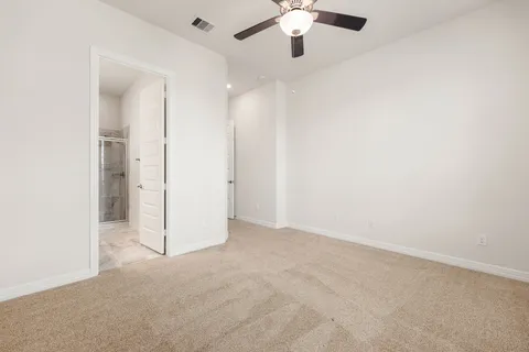 an empty room with chandelier fan