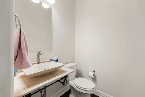 a bathroom with a sink a toilet and a mirror