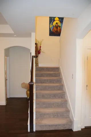 a view of a hallway with wooden floor and staircase