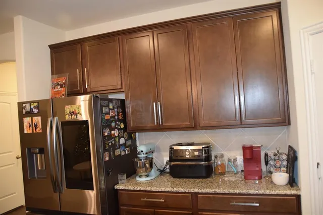 a kitchen with stainless steel appliances granite countertop a refrigerator and a sink