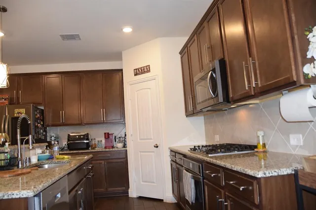 a kitchen with granite countertop stainless steel appliances and wooden cabinets