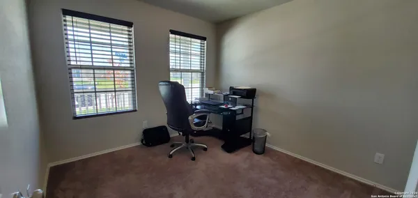 a view of a workspace with furniture and a window